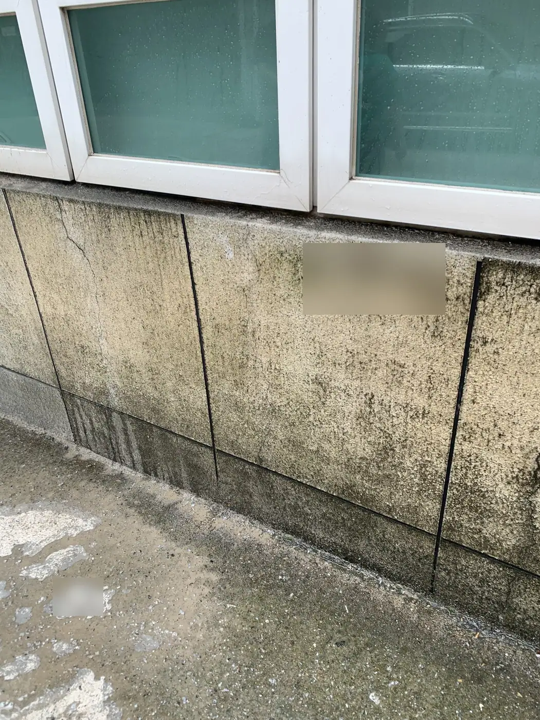 부산 강서구 사업장 건물 창 아래 하단 석재 판에 번진 검은 빗물 자국과 물때