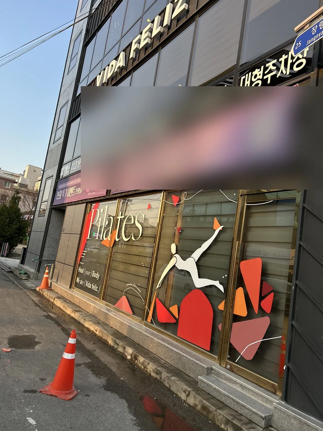 상가건물 1층 간판과 통유리 앞 도로의 작업 중간 장면