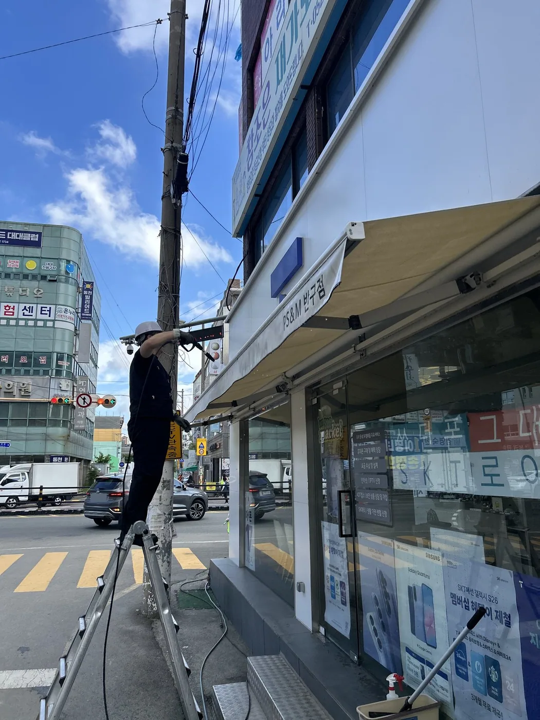 대로변 통신매장 어닝 아래 사다리를 세운 작업 전 모습