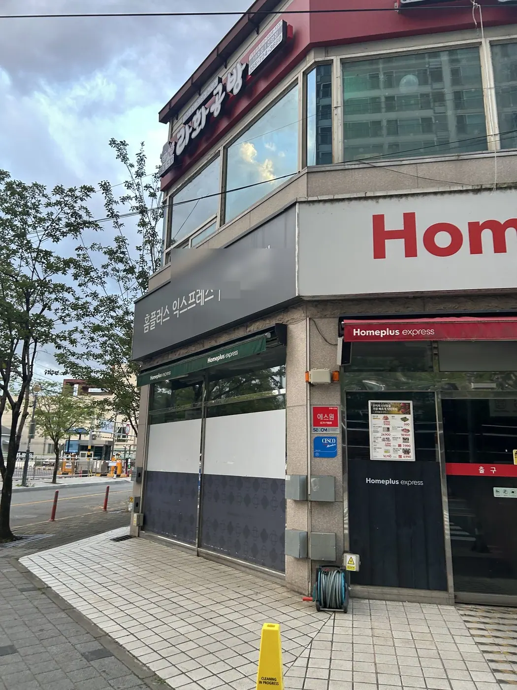 대형마트 매장 모서리의 판형 간판과 보라색 외벽 띠, 작업 중간 장면