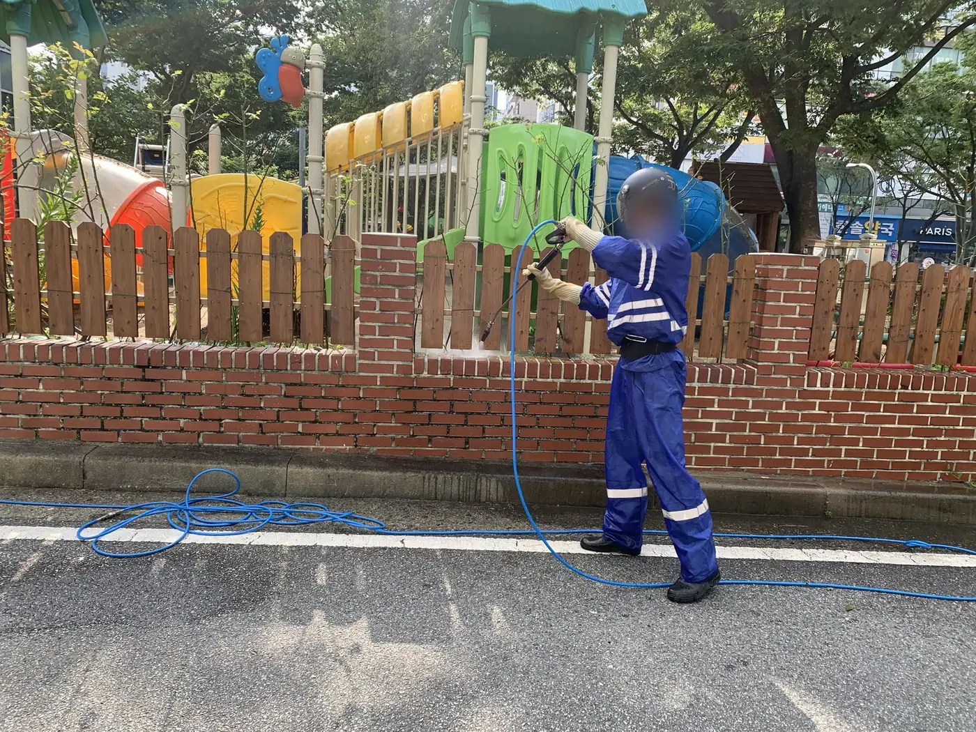 도로변 벽돌 담장을 따라 이동하며 세척하는 장면