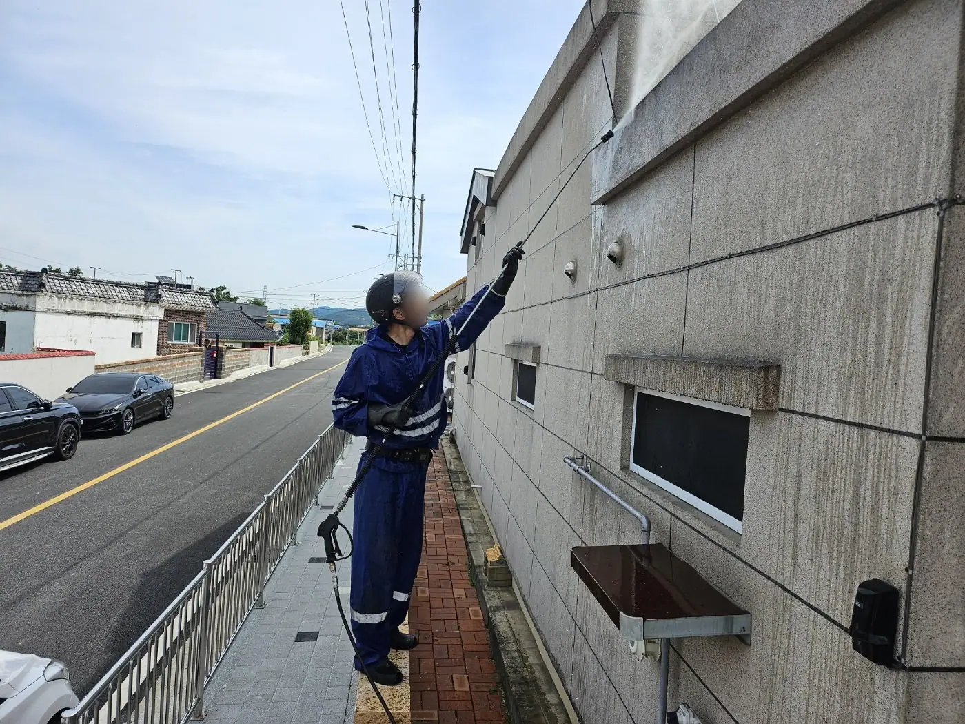 도로변 콘크리트 옹벽 상부를 세척하는 장면