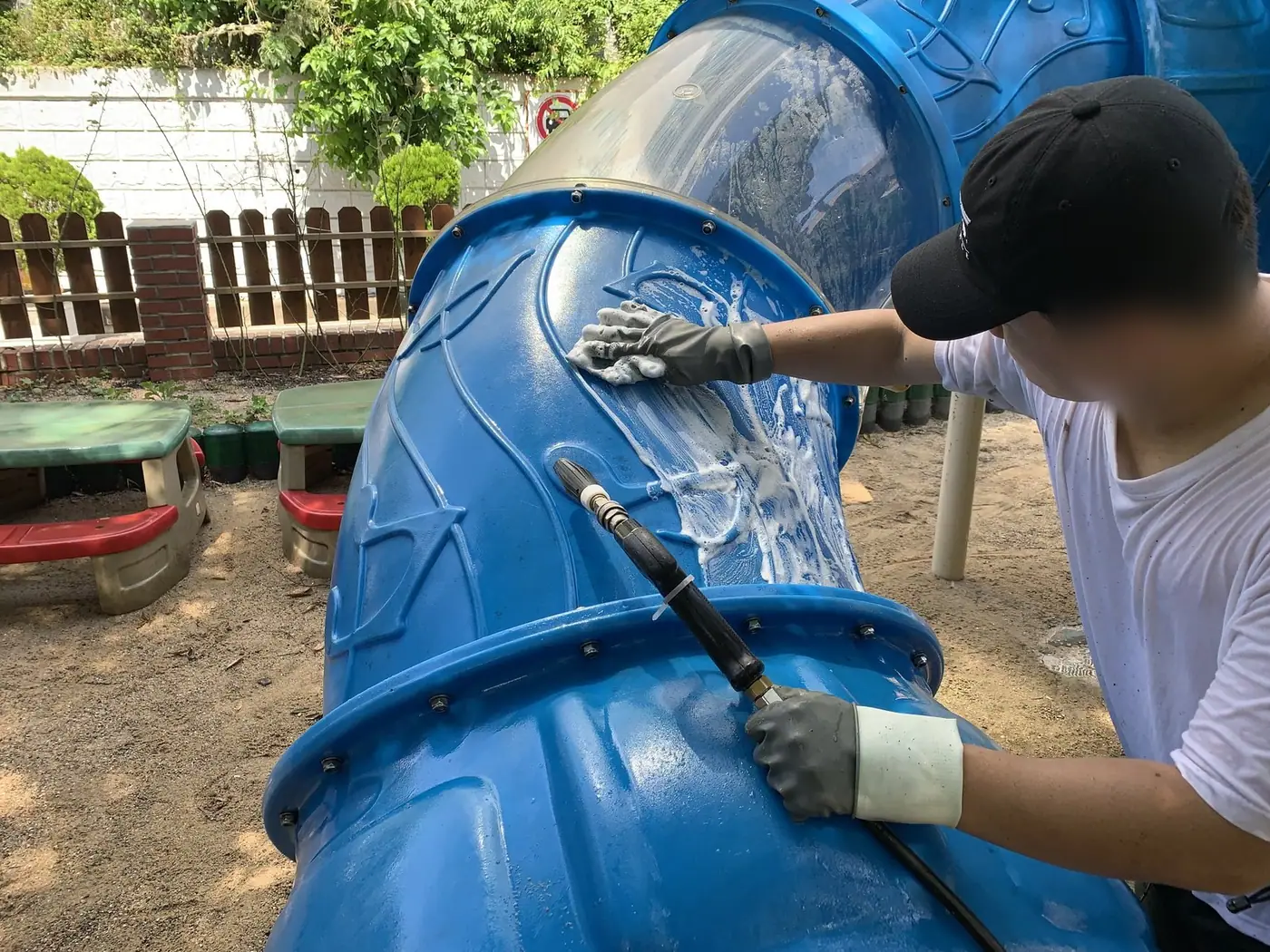 터널 놀이기구 표면을 스펀지와 솔로 바꿔 가며 닦는 장면
