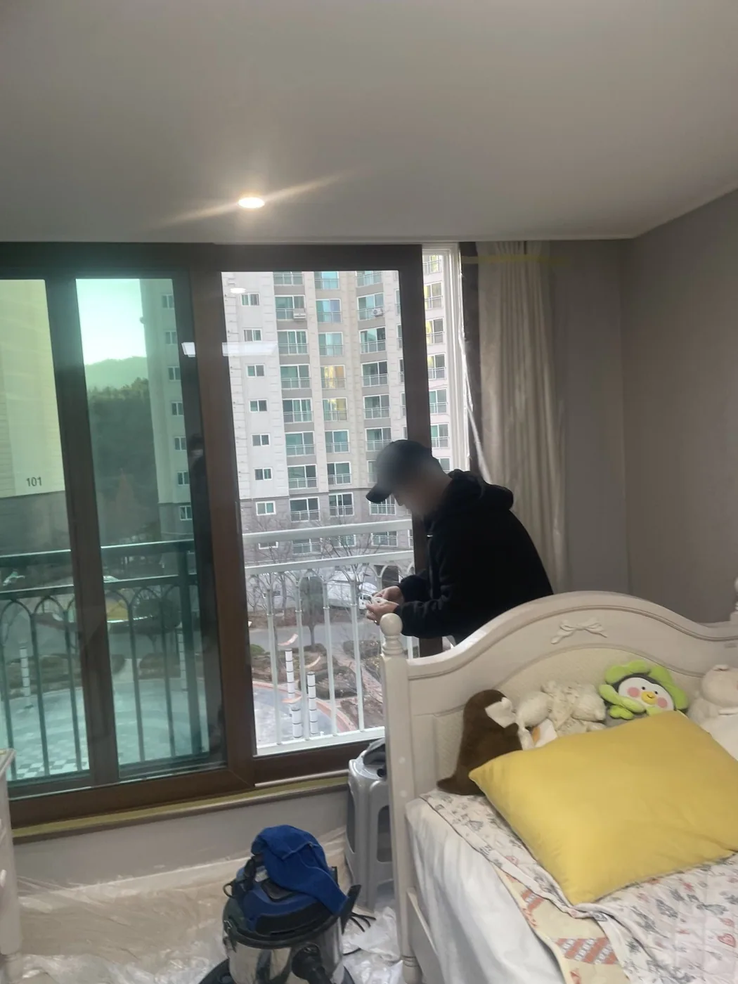 침실 창가에서 창틀을 청소하는 장면