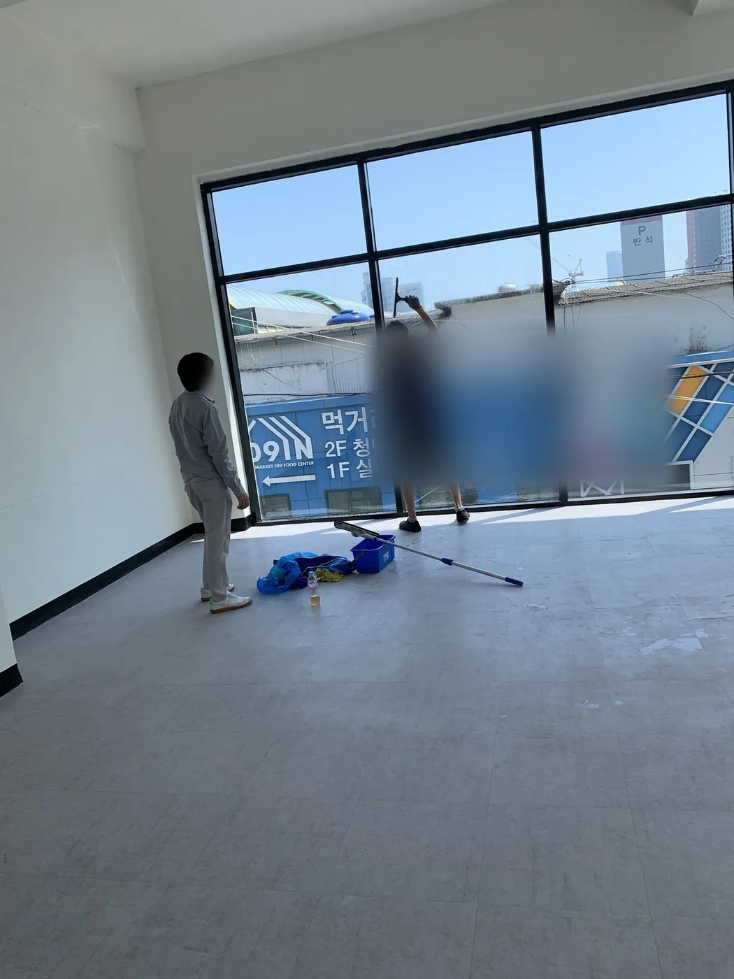 대형 유리면 앞에서 두 작업자가 각각 상부와 하부를 나눠 세척하는 장면