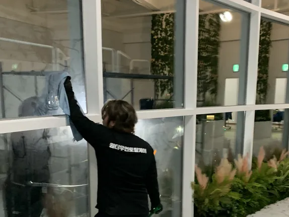 매장 통유리를 안쪽에서 닦는 작업자